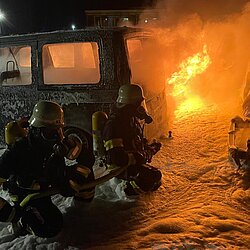 Feuerwehr löscht bei Dunkelheit brennende Fahrzeuge mit Schwerschaum 