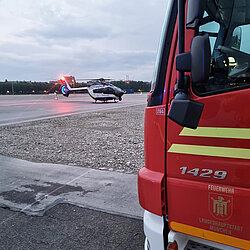 Rotes Feuerwehrfahrzeug am rechten Bildrand, im Hintergrund ein Polizeihubschrauber auf der Theresienwiese 