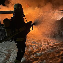 Feuerwehr löscht bei Dunkelheit brennende Fahrzeuge mit Schwerschaum 