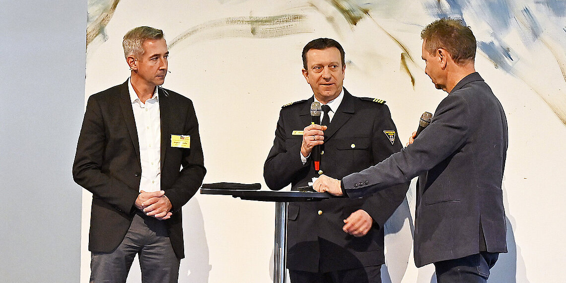 Referenten: Jürgen Wettlaufer, Leiter der Werkfeuerwehr der TUM und Jörg Fiebach, Abteilungsleiter Einsatzvorbereitung der Branddirektion München mit Moderator Roman Roell