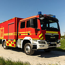 Gerätewagen Logistik auf einem Feldweg bei klarem Himmel