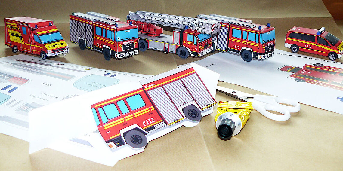 Papiermodelle von Feuerwehrfahrzeugen zum Ausschneiden und Zusammenbauen auf einem Tisch